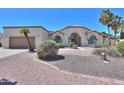 Charming home featuring desert landscaping, arched windows, and a two-car garage at 2077 N Lake Shore Dr, Casa Grande, AZ 85122