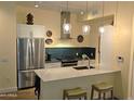 Contemporary kitchen featuring stainless steel appliances, breakfast bar, and stylish pendants at 3131 N Central Ave # 3001, Phoenix, AZ 85012