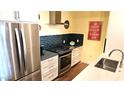 A modern kitchen with stainless steel appliances and blue tiled backsplash at 3131 N Central Ave # 3001, Phoenix, AZ 85012
