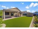 Wide shot of a spacious backyard with artificial grass, covered patio, and exterior storage at 33290 N Roadrunner Ln, San Tan Valley, AZ 85144