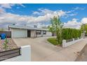 Well-maintained single-story home with a spacious concrete driveway, garage and grassy front yard at 4113 N 10Th Pl, Phoenix, AZ 85014