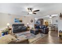 Spacious living room with hardwood floors, comfortable seating, ceiling fan, and open access to dining area at 4432 E Carmel Ave, Mesa, AZ 85206