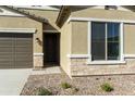 Close-up of a home's entrance showing the stucco exterior, stone accents, and a well-maintained yard at 4946 W Weeping Willow Way, Laveen, AZ 85339