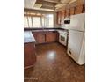 Kitchen features laminate countertops, wood cabinets, and white appliances at 5220 E Winchcomb Dr, Scottsdale, AZ 85254