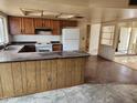An outdated kitchen with laminate countertops and a breakfast bar connecting to the living area at 5220 E Winchcomb Dr, Scottsdale, AZ 85254