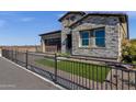 Beautiful single-Gathering home featuring stone accents, a dark brown garage, and manicured landscaping at 5748 E Sierra Morena St, Mesa, AZ 85215
