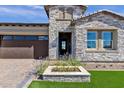 Charming single-Gathering home with stone accents, beautiful landscaping, and a dark brown garage at 5748 E Sierra Morena St, Mesa, AZ 85215