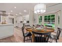 Dining room with a round table, black chairs, and a view of the adjacent kitchen and outdoor scenery at 5801 E Exeter Blvd, Phoenix, AZ 85018