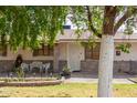 Inviting single-story house featuring a decorative security door, manicured lawn, and mature trees at 6235 N 25Th Ave, Phoenix, AZ 85015