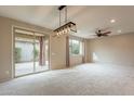 Bright living room boasting carpeted floors, a modern light fixture, and access to a patio at 6853 E Posada Cir, Mesa, AZ 85212