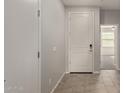 Bright foyer with tile flooring, white walls and a door with modern electronic lock at 7133 N 123Rd Dr, Glendale, AZ 85307
