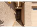 Inviting front entrance featuring a classic wood door and neutral-toned stucco walls at 7133 N 123Rd Dr, Glendale, AZ 85307