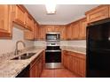 Traditional kitchen with granite countertops, stainless steel appliances, and wood cabinetry at 8625 E Belleview Pl # 1012, Scottsdale, AZ 85257