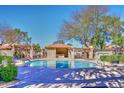 Sparkling community pool area featuring lounge chairs and covered seating for relaxation at 8625 E Belleview Pl # 1012, Scottsdale, AZ 85257