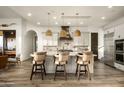 Stylish kitchen with a large island, pendant lighting, stainless steel appliances, and comfortable seating at 9188 E Bajada Rd, Scottsdale, AZ 85262