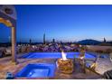 Inviting outdoor pool and spa with rock waterfall and fire pit, providing a luxurious desert oasis at 9188 E Bajada Rd, Scottsdale, AZ 85262