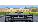 Outdoor dining set on a paved patio with a well-maintained lawn and perimeter landscaping at 9734 E Spiral Ave, Mesa, AZ 85212