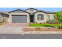 Charming single-story home with gray stucco, complemented by a well-manicured lawn, and a two car garage at 9734 E Spiral Ave, Mesa, AZ 85212
