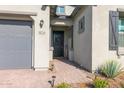 Inviting front entrance with a gray front door, brick walkway, and desert landscaping at 9734 E Spiral Ave, Mesa, AZ 85212
