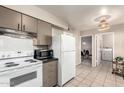 Fully equipped kitchen featuring modern appliances and neutral cabinetry adjacent to the dining area at 10547 W Coggins Dr, Sun City, AZ 85351