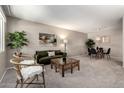 Comfortable living room featuring neutral walls, plush carpet, and stylish furnishings at 10547 W Coggins Dr, Sun City, AZ 85351