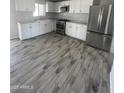 A bright kitchen features white cabinets, stainless steel appliances, and light gray wood-look tile floors at 1132 E 9Th Pl, Casa Grande, AZ 85122