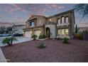 Two-story home features a three-car garage and desert landscaping creating an inviting curb appeal at 12910 W Tuckey Ln, Glendale, AZ 85307