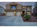Inviting two-story home boasting a spacious driveway, desert landscaping, and a charming red front door at 12910 W Tuckey Ln, Glendale, AZ 85307