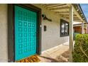 Close-up of a turquoise front door with unique square pattern design and modern hardware at 1326 E Almeria Rd, Phoenix, AZ 85006