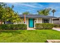 Charming single story house with a lush green lawn and a vibrant turquoise door at 1326 E Almeria Rd, Phoenix, AZ 85006