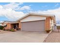 Exterior shot of a one-story home showing a two car garage and brick facade at 1399 S Palo Verde Dr, Apache Junction, AZ 85120