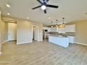 Spacious living room flows into open kitchen, complete with tile floors and a modern ceiling fan at 15422 S Sequoia Cir, Arizona City, AZ 85123