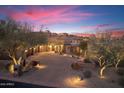 Beautiful home at twilight with a brick driveway, desert landscaping, and exterior lighting at 15956 E Tombstone Trl, Fountain Hills, AZ 85268