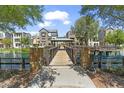 Stunning lake view featuring a wooden bridge, gazebo, and waterfront residences on a sunny day at 1679 E Dogwood Ln, Gilbert, AZ 85295