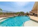Sparkling backyard pool with rock waterfall feature and covered patio seating area at 17005 S Coleman St, Phoenix, AZ 85045