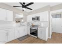 Modern kitchen featuring white cabinets and countertops, stainless steel appliances, and stylish wood-look flooring at 1715 W Carol Ave, Mesa, AZ 85202