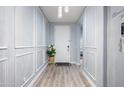 Inviting entryway with light gray walls, decorative wall trim, wood-look floors, and a decorative front door at 17545 W Lilac St, Goodyear, AZ 85338