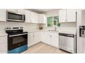 The kitchen features new white cabinets, stainless steel appliances, and a window at 2356 W Catalina Ave, Mesa, AZ 85202