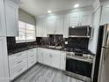 Modern kitchen featuring white cabinets, stainless steel appliances, and dark granite countertops at 2945 N 19Th Ave # 78, Phoenix, AZ 85015