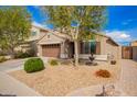 Single-story home with a two car garage, well-manicured lawn, and mature landscaping at 39984 W Hopper Dr, Maricopa, AZ 85138