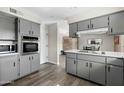 Updated kitchen with gray cabinets, stainless steel appliances, and wood-look floors, offering ample storage at 4129 W Caron St, Phoenix, AZ 85051