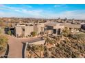 Unique, contemporary home with neutral tones surrounded by desert plants and a paved driveway at 41823 N 111Th Pl, Scottsdale, AZ 85262