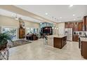 Bright open-concept living space with a kitchen island, tile floors, and a cozy seating area at 42920 W Kingfisher Dr, Maricopa, AZ 85138