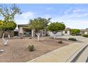 Well-maintained front yard with desert landscaping, trees, and a cozy front porch at 4665 E Dartmouth St, Mesa, AZ 85205