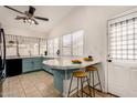 Open kitchen with breakfast bar, black appliances, bright countertops, and access to the backyard at 7120 W Columbine Dr, Peoria, AZ 85381