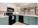 Charming kitchen featuring black appliances, white countertops, and bright teal lower cabinets at 7120 W Columbine Dr, Peoria, AZ 85381