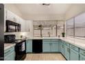 Bright kitchen featuring black appliances, white countertops, and light teal lower cabinets at 7120 W Columbine Dr, Peoria, AZ 85381