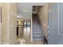 Light filled condo foyer featuring tiled floors, staircase to the upper level and an open dining area at 7726 E Baseline Rd # 156, Mesa, AZ 85209