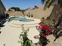 Backyard pool with spa and desert landscaping including bougainvillea and sunflowers at 7908 W Harmony Ln, Peoria, AZ 85382