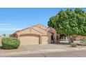 Charming home with a well-maintained lawn and a large three-car garage and beautiful mature landscaping at 7908 W Harmony Ln, Peoria, AZ 85382